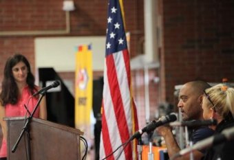 A photo of Veterans sitting in front of microphones making statements about their injuries